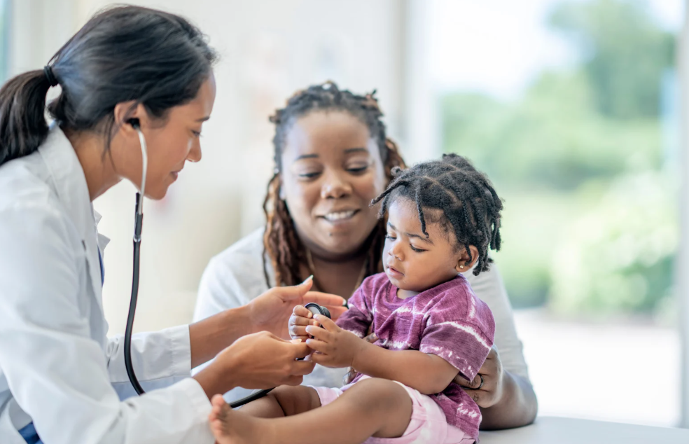 a mom and her young daughter at a family medical appointment with a pediatrician